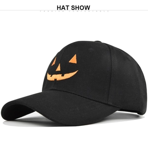 Detail of black baseball cap featuring orange Halloween pumpkin smile embroidery