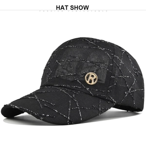 Close-up of black baseball cap with silver line texture and metallic gold R-logo detail