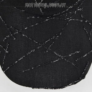 Detailed view of black baseball cap with metallic silver embroidery and textured fabric