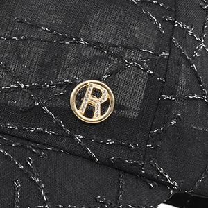 Detail of baseball cap fabric with silver embroidery and golden crystal R metal buckle