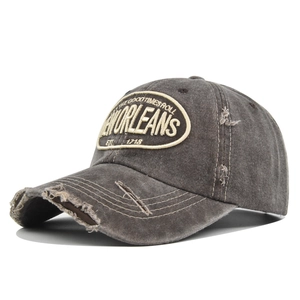 Detail of vintage New Orleans embroidery and distressed edges on washed canvas cap
