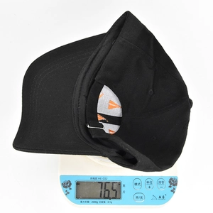 Detailed view of Halloween baseball cap weight on electronic scale showing 76.5 grams