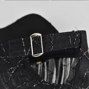 Close-up of black baseball cap back strap with silver metal buckle and grid stitching