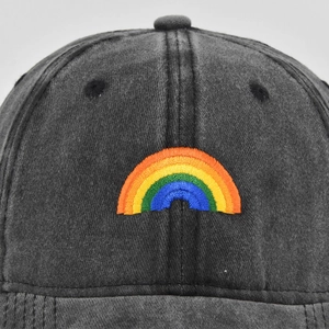 Close-up of rainbow embroidery on a vintage washed dark grey baseball cap with texture