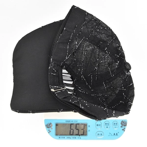 Detailed weight measurement of the black baseball cap showing 65.3g on a scale
