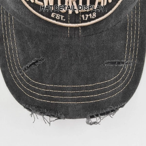 Detailed macro of distressed grey cotton cap brim with yellow stitching and embroidery