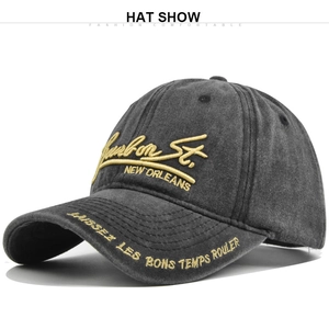 Detailed macro view of gold 3D embroidery on dark grey washed cotton baseball cap