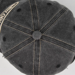Detailed top view of vintage washed black baseball cap with contrast stitching and embroidery