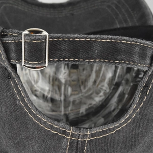 Macro detail of washed denim baseball cap with adjustable metal buckle and stitching