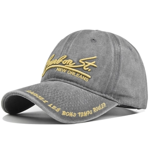 Detail of 3D embroidery on vintage grey washed cotton baseball cap with yellow text