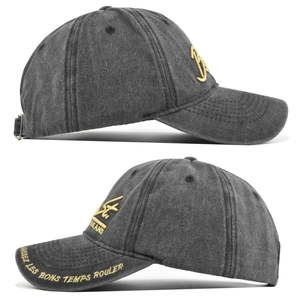 Detailed close-up of 3D gold embroidery and French text on washed cotton baseball cap