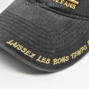 Close-up of golden embroidery and washed canvas texture on a vintage baseball cap