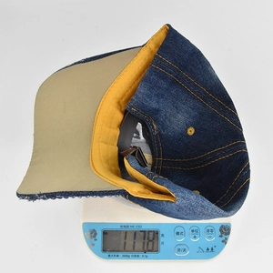 Detailed view of rhinestone baseball cap on scale showing weight of 117.8 grams