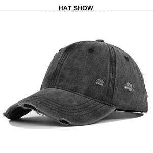 Detailed macro shot of vintage distressed charcoal grey baseball cap with ripped holes