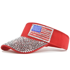 Detail of red sun visor hat featuring rhinestone US flag and sparkling brim gems