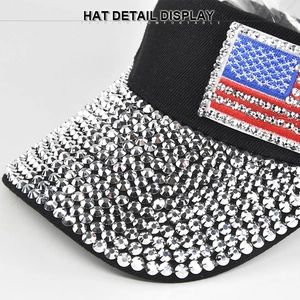 Detailed macro view of rhinestone-studded brim and American flag patch on a black baseball cap