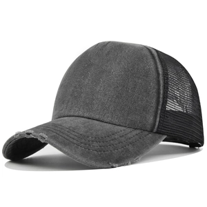 Detail view of the distressed washed cotton brim and breathable mesh of the trucker cap
