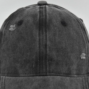 Detailed close-up of distressed cotton fabric and embroidery on a vintage baseball cap