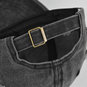 Detail of adjustable metal buckle and vintage washed cotton fabric on the baseball cap