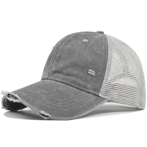 Detail of gray distressed baseball cap with worn holes and breathable white mesh back