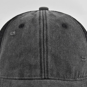 Detailed macro shot of distressed fabric and stitching on a dark grey vintage baseball cap
