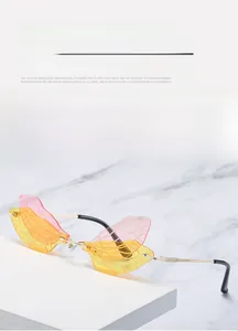 Macro shot of oversized butterfly wing sunglasses with pink yellow gradient lenses