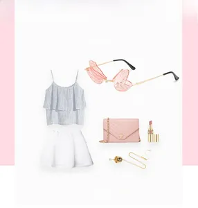 Flat lay of pink butterfly sunglasses styled with a white skirt and a pink chain bag
