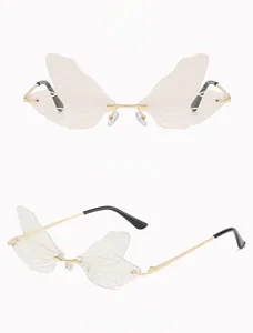 Macro detail of butterfly wing sunglasses with golden frames and pink lenses