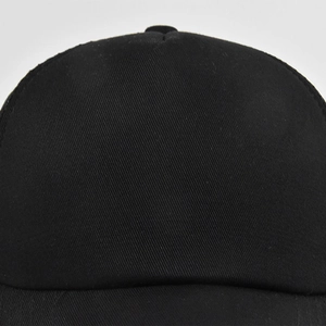Close-up of high-density black twill cotton fabric on the structured baseball cap front