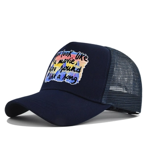 Détail de la casquette trucker bleu marine avec filet respirant et citation imprimée