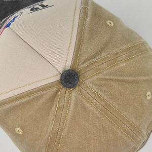 Détail du haut de la casquette kaki délavé montrant la couronne à six pans et le bouton
