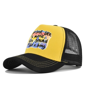 Détail d'une casquette trucker jaune avec texte de chanson et filet de ventilation