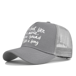 Detail of grey trucker hat featuring white text print and breathable mesh back