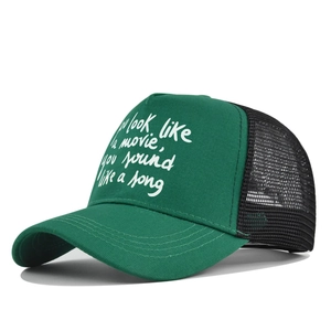 Close-up of green and black trucker hat with quote print and breathable mesh back