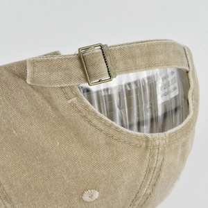 Detail of vintage beige cotton baseball cap with adjustable metal buckle and corduroy texture