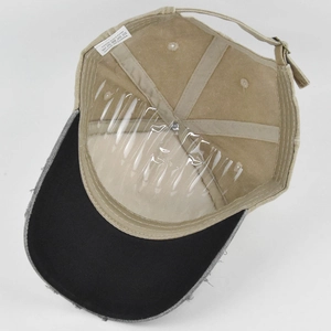 Detail view of cotton baseball cap interior showing sewing and distressed brim edge