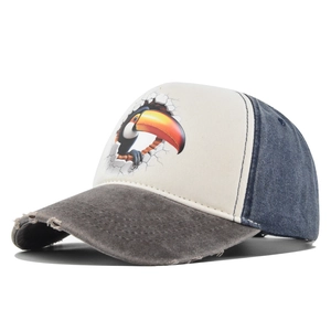 Detail van de versleten rand en toekanprint op een tweekleurige trucker baseballpet