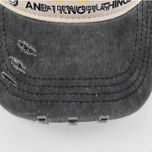 Detailed macro view of distressed denim baseball cap brim with stitching and fraying