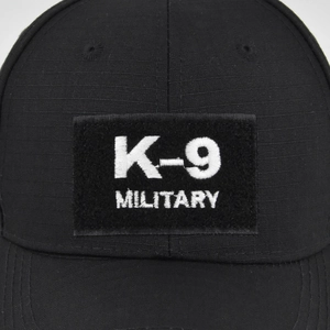 Close-up of K-9 Military embroidery and velcro patch on black tactical baseball cap