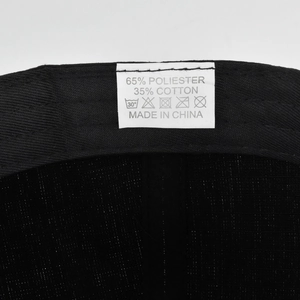 Macro view of the 65% polyester 35% cotton fabric and wash care label inside the cap