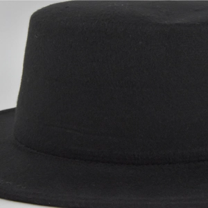 Extreme close-up of black felt texture on classic wool jazz hat crown and brim seam
