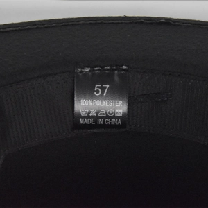 Macro shot of fedora hat interior showing size 57 label and 100% polyester sweatband