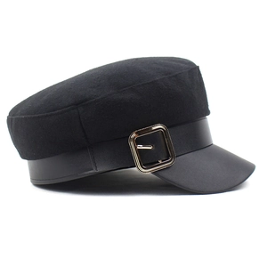 Close-up of a black wool newsboy hat featuring a PU leather brim and golden buckle detail