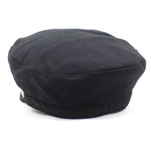 Detail of black wool baker boy hat featuring a decorative braided rope band on the brim
