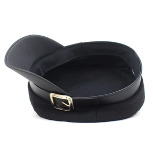 Detail of wool baker boy hat with black faux leather brim and gold square buckle