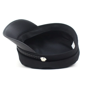 Detail of black navy cap featuring a faux leather brim and silver metal side buttons