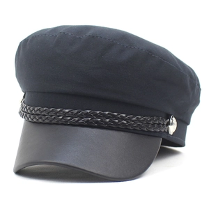 Detail of black baker boy hat with leather brim and decorative braided cord on top