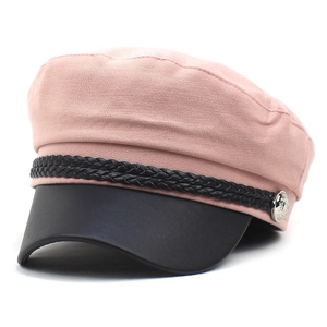 Detailed close-up of pink cotton newsboy cap with black leather brim and metal button decoration