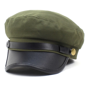 Detailweergave van de legergroene militaire pet met zwarte leren klep en gouden knopen