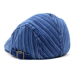 Détail du béret en coton à rayures bleues montrant la boucle réglable et le tissu en denim